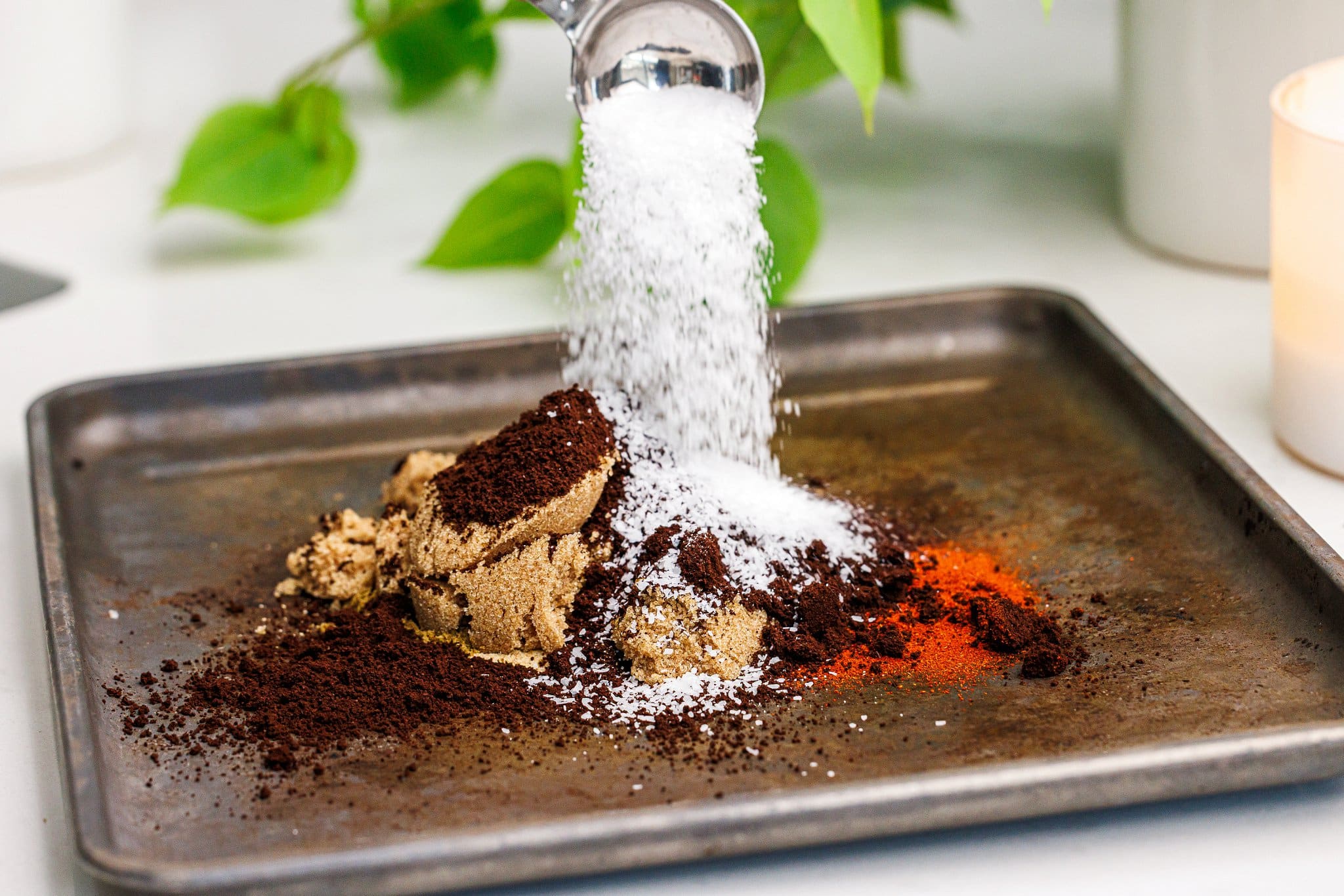 Adding kosher salt to coffee and spices on a tray.