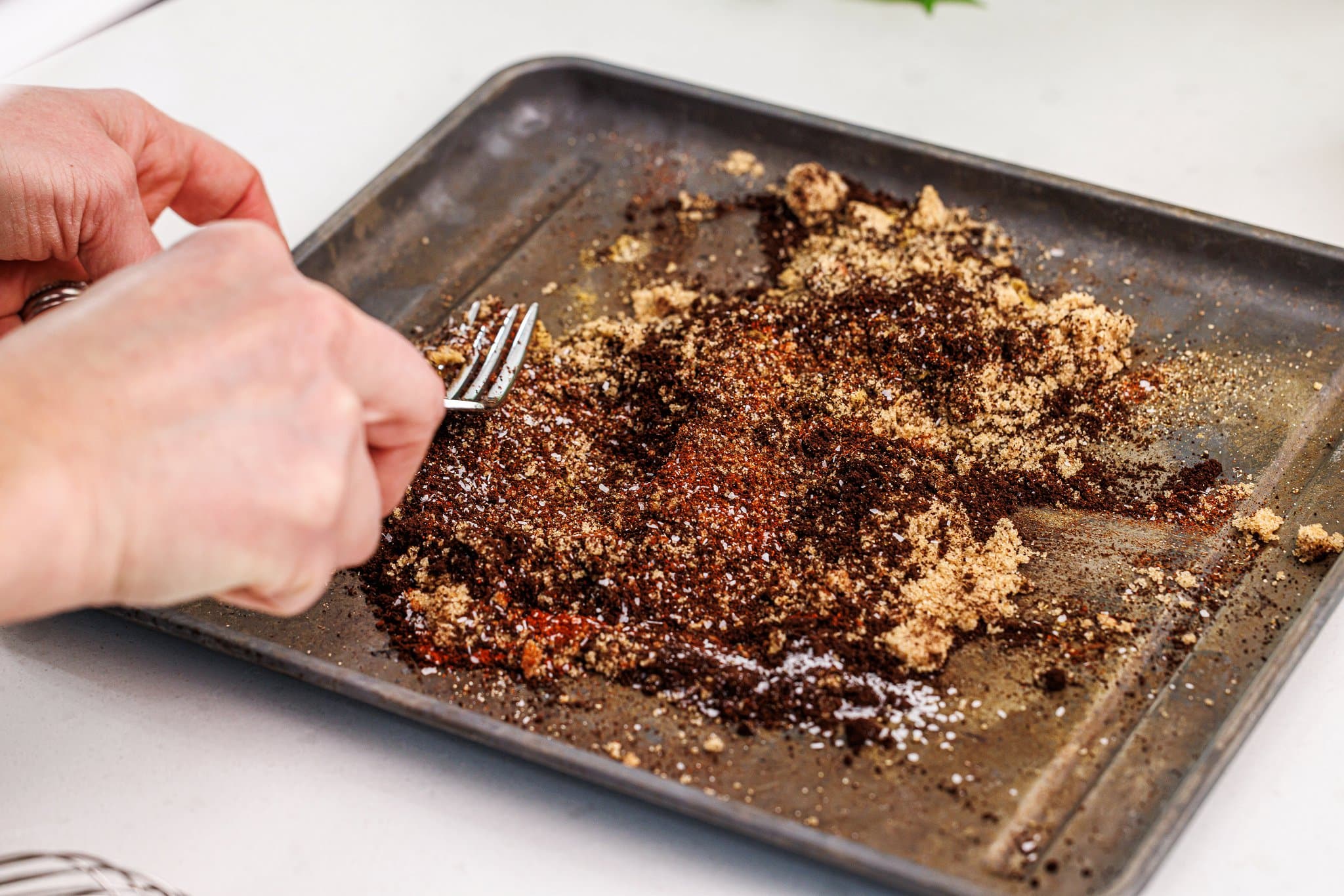 Mixing together coffee spice rub with a fork.
