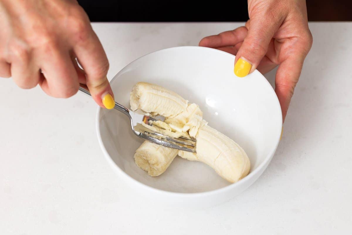 Mashing bananas in a bowl.