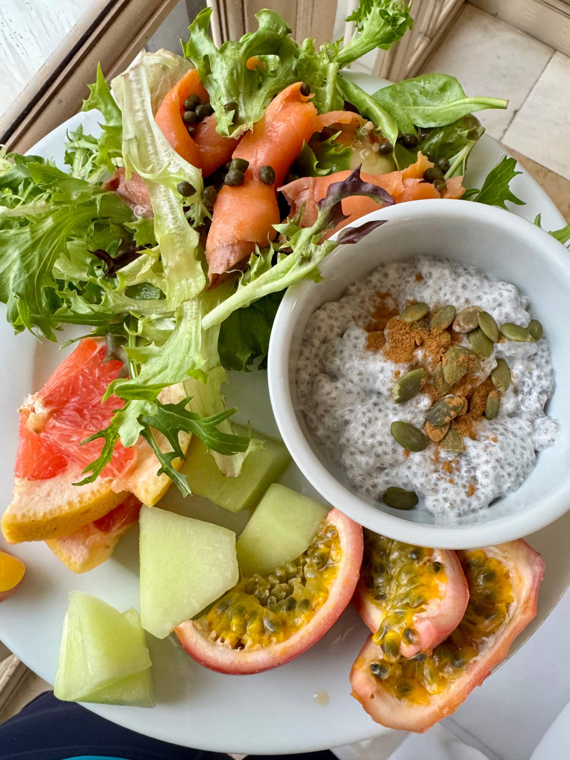 Breakfast buffet plate with fresh fruit and veggies and chia seed pudding.