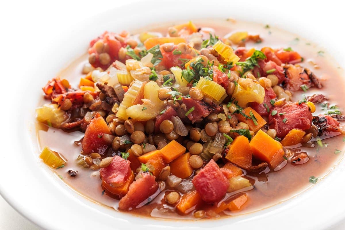 Lentil soup with bacon and topped with fresh parsley.