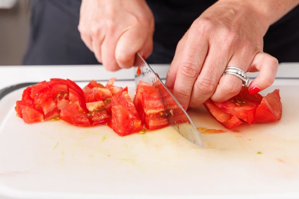 Cutting tomatoes into chunks.