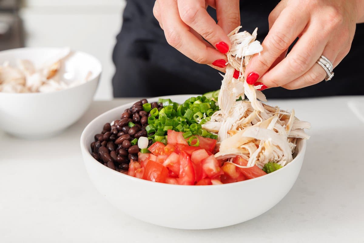 Assembling chicken and black bean salad.