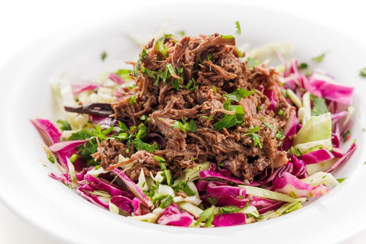 Shredded beef and cabbage slaw in a burrito bowl.