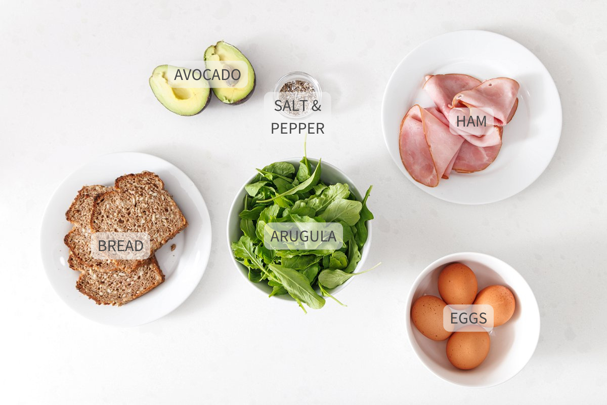 Labeled ingredients for avocado toast on a white counter.