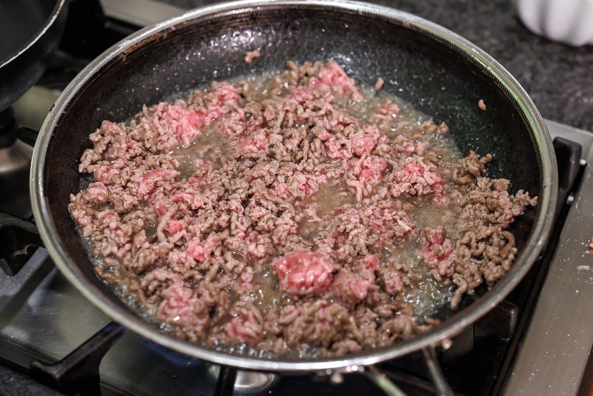 Cooking ground lamb in a skillet.