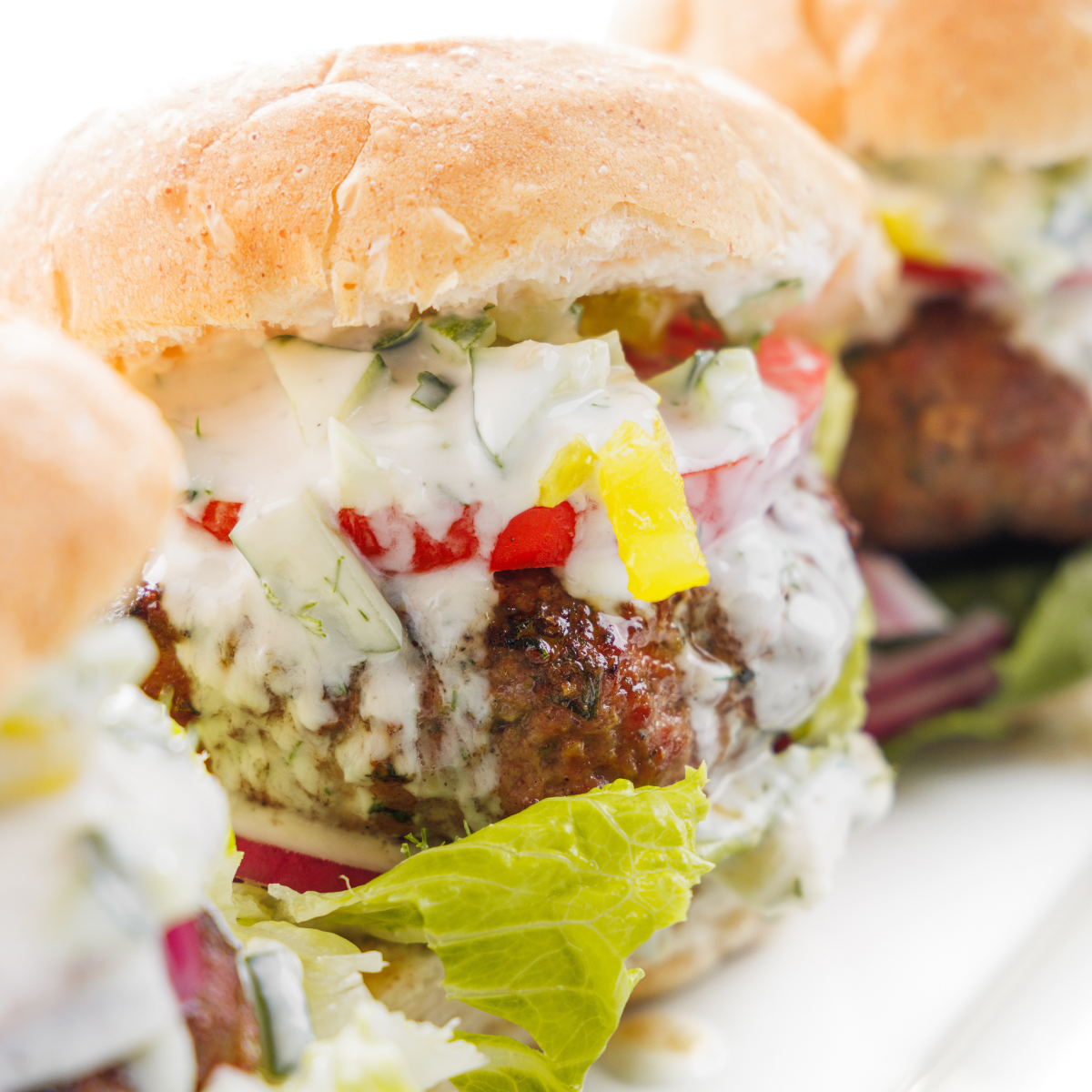Greek lamb burgers with tzatziki sauce dripping down the sides.