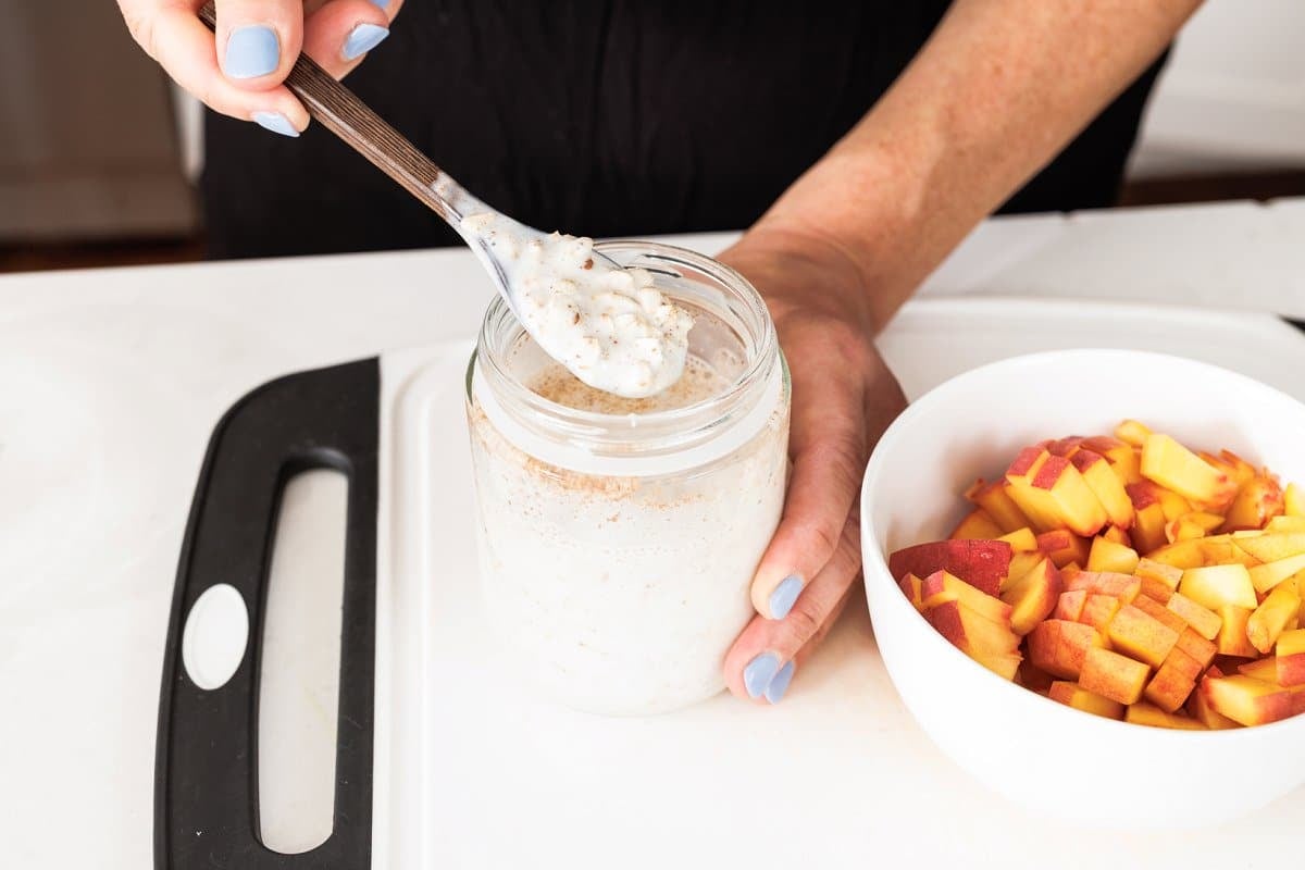 Scooping some overnight oats out of jar.