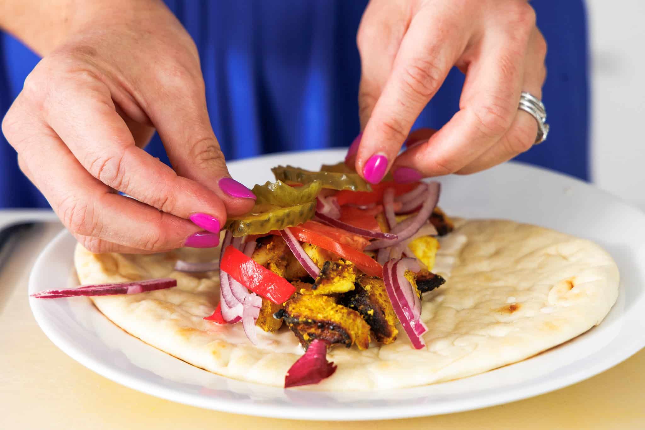 Arranging chicken shawarma naan wrap.