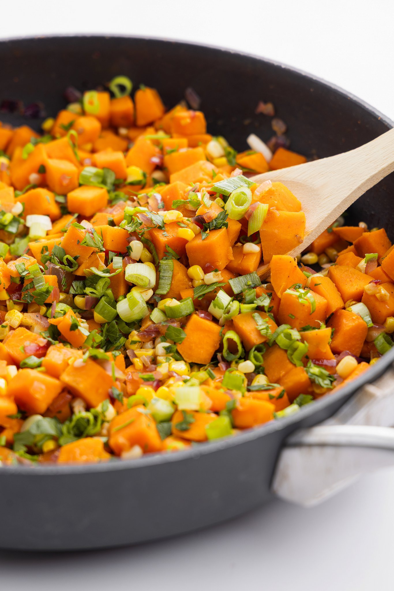 Sweet potato and corn succotash garnished with scallions and parsley.