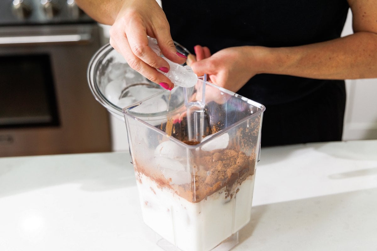 Adding ice cubes to blender.