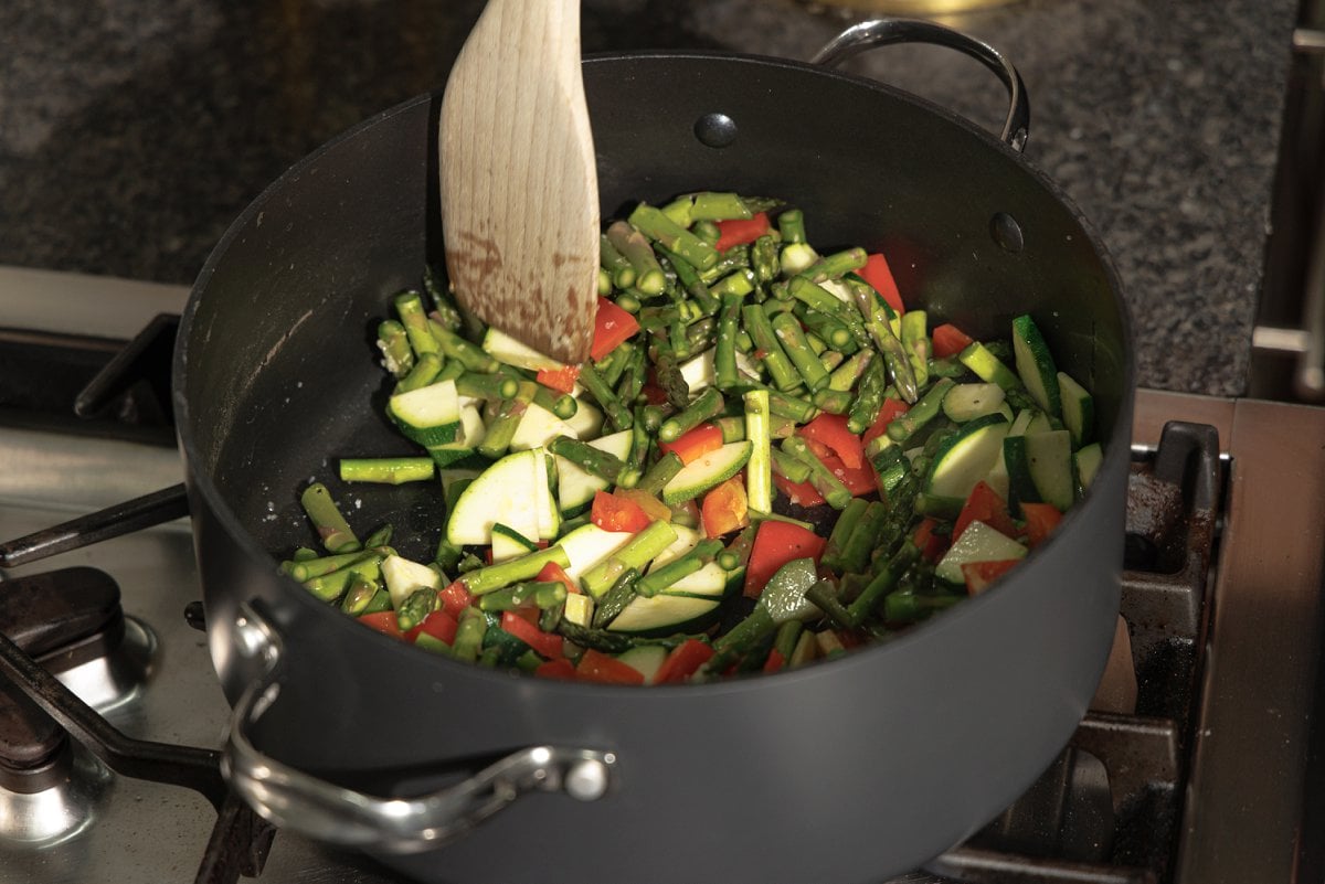 Veggies added to a large skillet.