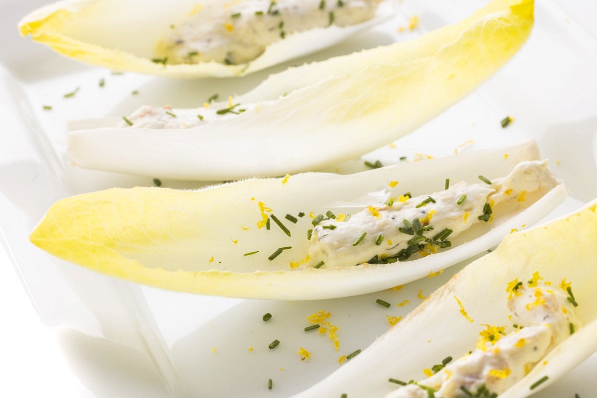 Endive leaves with smoked grouper spread topped with chives and lemon zest.