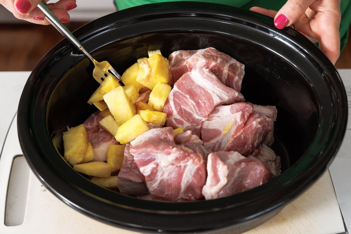 Pork shoulder and pineapple chunks in slow cooker.